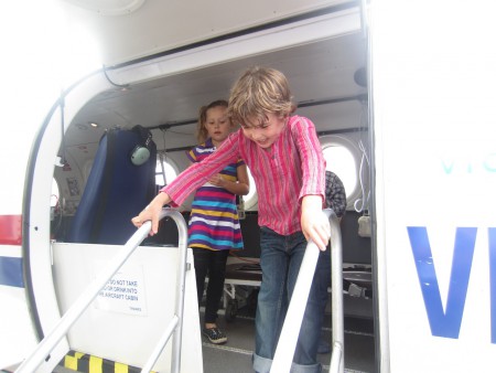 Xavier och Linnea utforskar the flying doctors flygplan på Yarraville festivalen